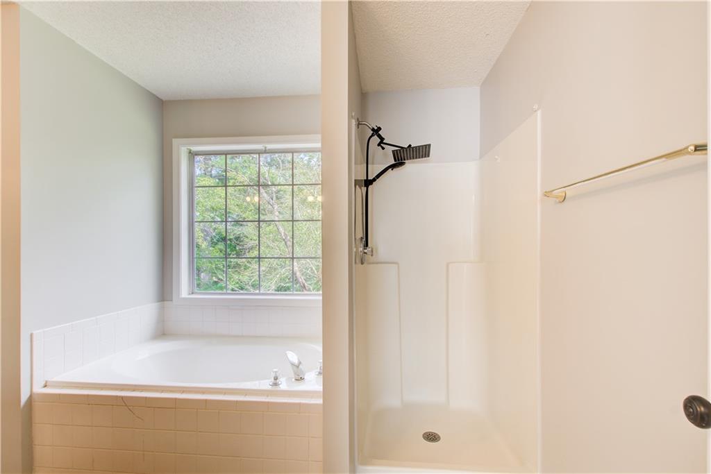 837 Ravins Way Stockbridge, GA 30281 - Photo 16 of 32 a bathroom with a bathtub and a shower