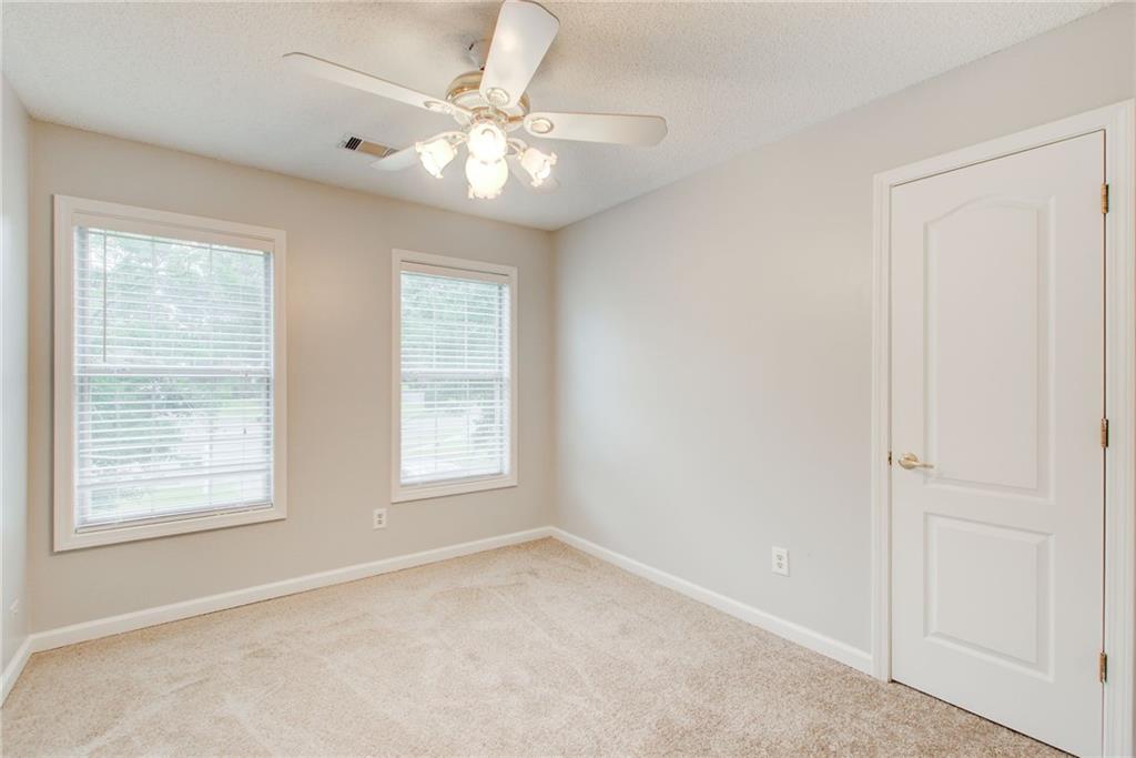 837 Ravins Way Stockbridge, GA 30281 - Photo 18 of 32 an empty room with chandelier fan and windows