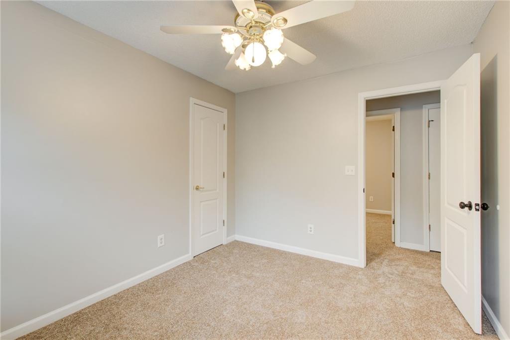 837 Ravins Way Stockbridge, GA 30281 - Photo 19 of 32 an empty room with a chandelier fan and closet area