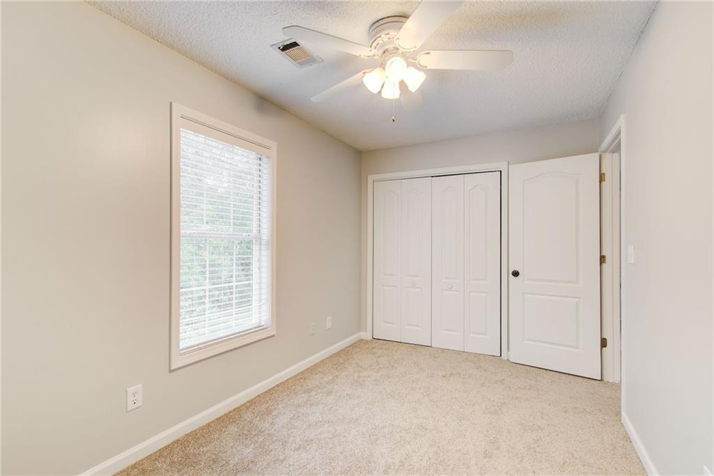 837 Ravins Way Stockbridge, GA 30281 - Photo 21 of 32 an empty room with windows and fan