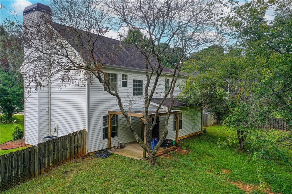 837 Ravins Way Stockbridge, GA 30281 - Photo 25 of 32 a view of backyard with wooden fence and a large tree