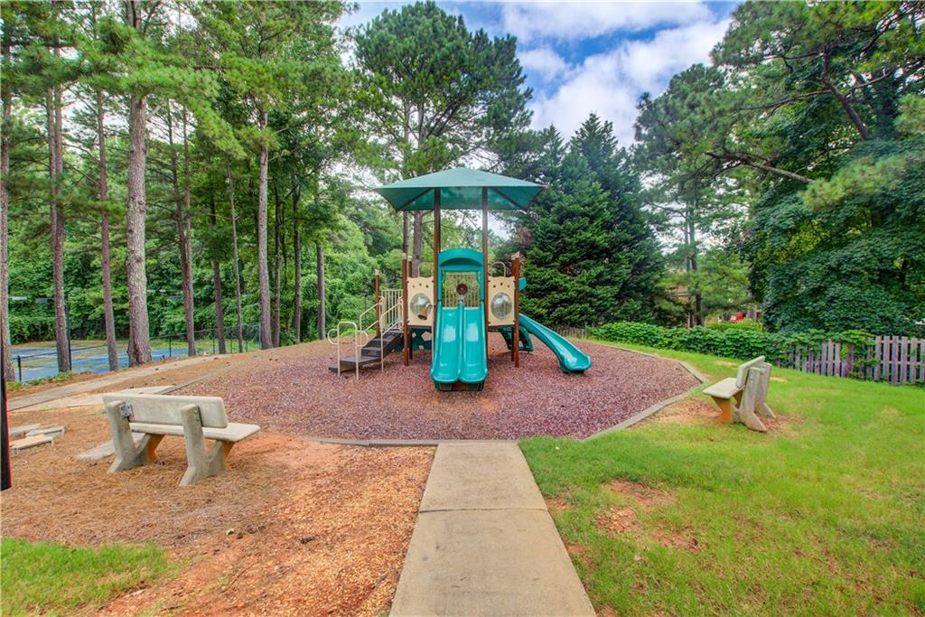 837 Ravins Way Stockbridge, GA 30281 - Photo 31 of 32 a view of a backyard with a slide trees and wooden fence