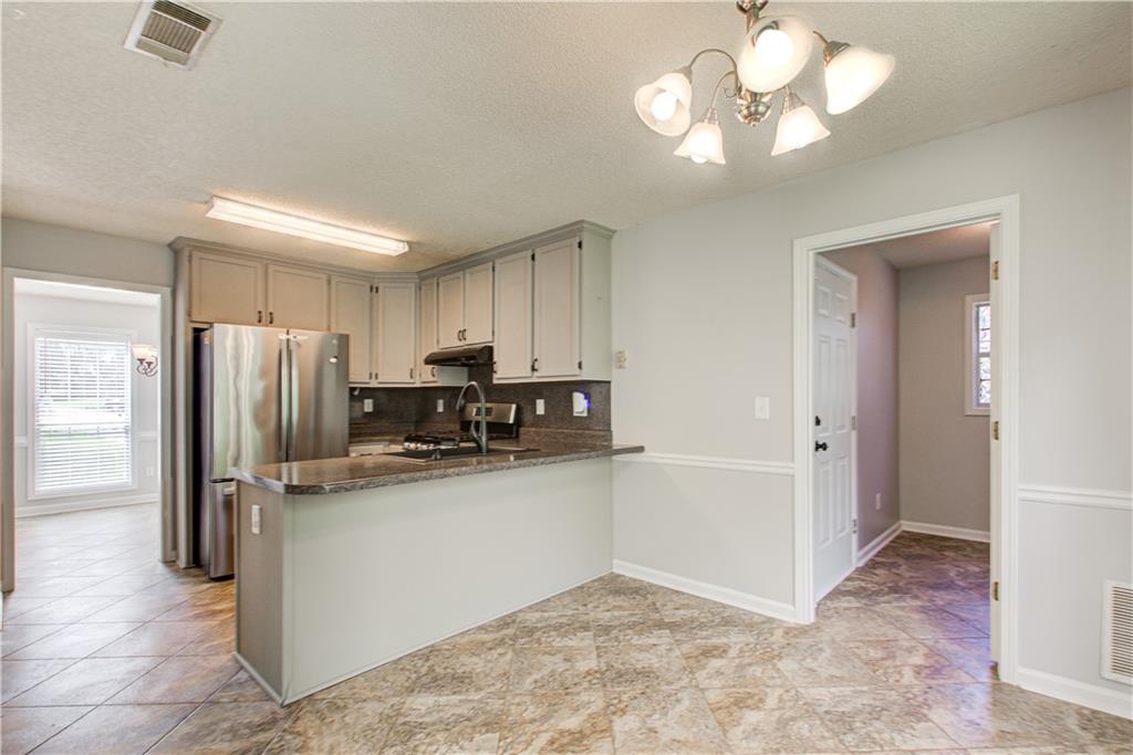 837 Ravins Way Stockbridge, GA 30281 - Photo 5 of 32 a kitchen with stainless steel appliances granite countertop a refrigerator a oven a sink a stove and a refrigerator