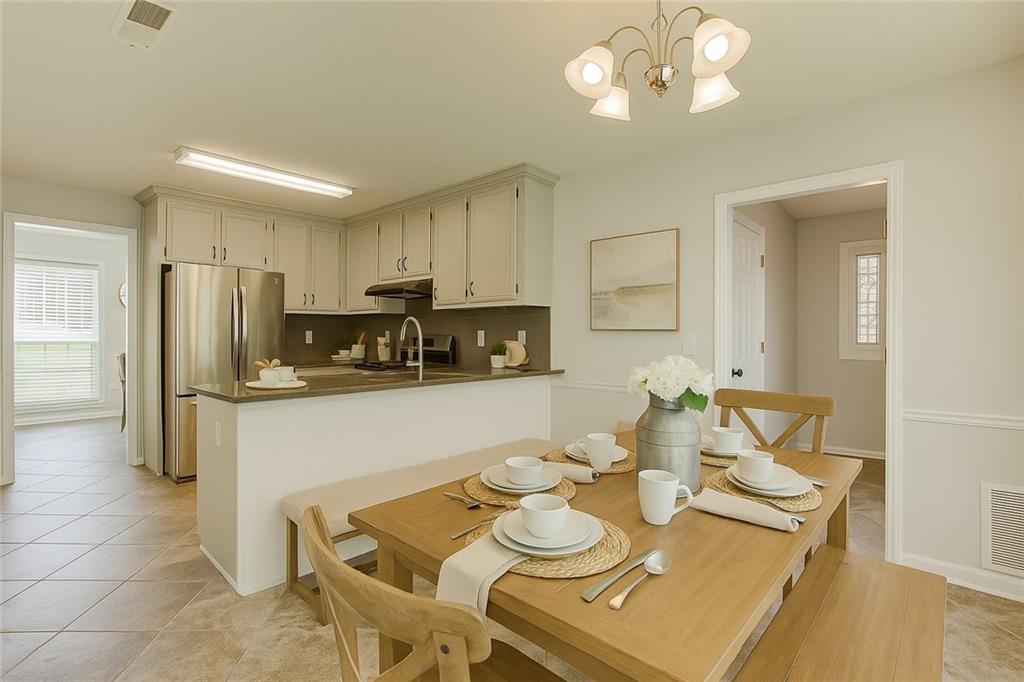 837 Ravins Way Stockbridge, GA 30281 - Photo 6 of 32 a kitchen with stainless steel appliances granite countertop a dining table and chairs