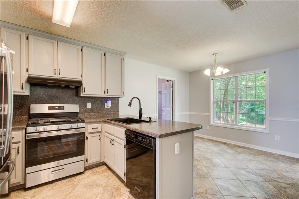 837 Ravins Way Stockbridge, GA 30281 - Photo 7 of 32 a kitchen with stainless steel appliances granite countertop a stove a sink and a microwave