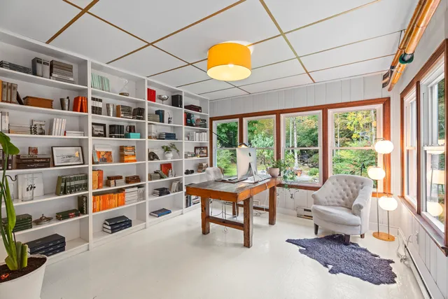 a living room with furniture cabinets and a large window