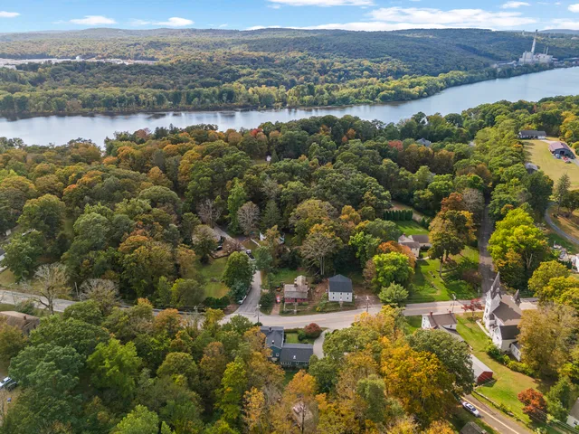 an aerial view of residential houses with outdoor space and trees