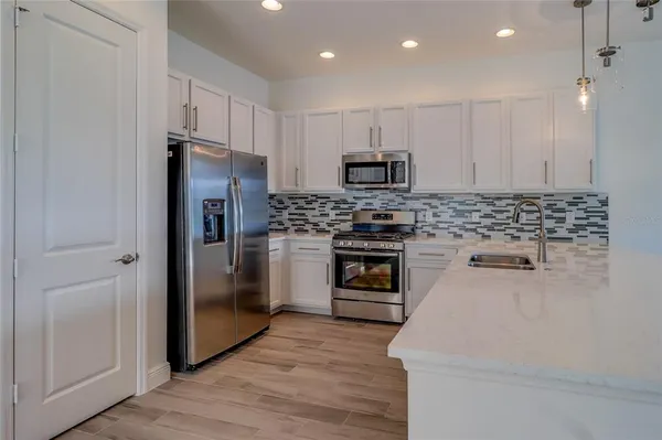 a kitchen with kitchen island a sink stainless steel appliances and cabinets