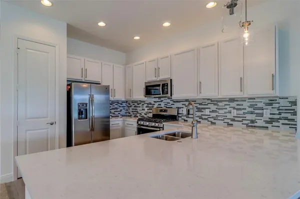 a kitchen with refrigerator a microwave a stove and cabinets