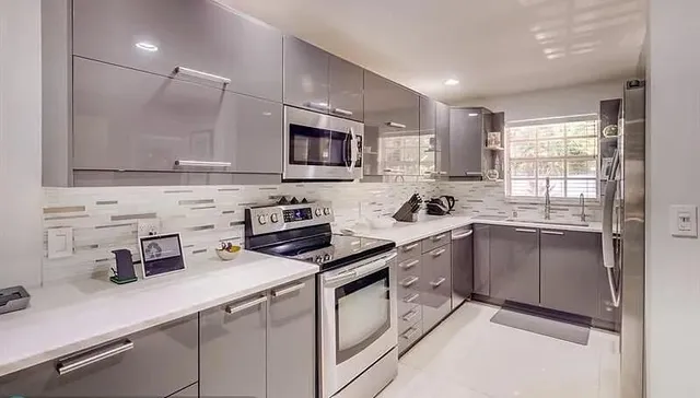 a kitchen with granite countertop a sink stainless steel appliances and cabinets
