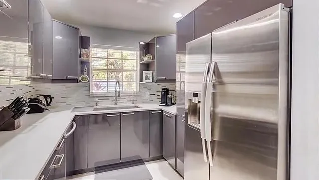 a kitchen with a sink refrigerator and window