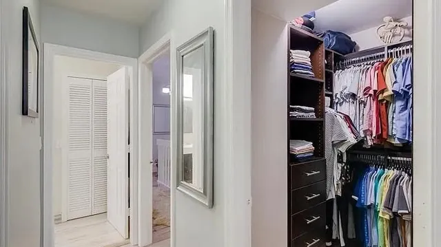 a view of walk in closet with clothes and shoes