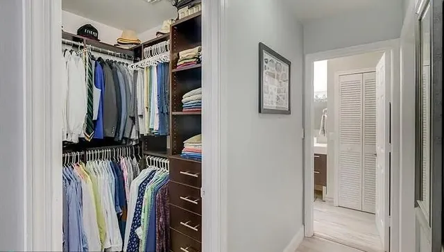 a view of walk in closet with clothes