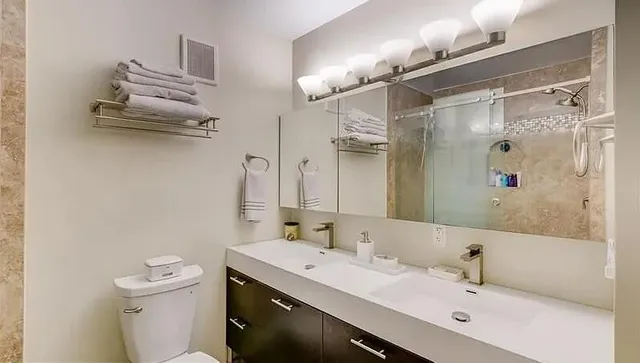 a bathroom with a sink a toilet and shower