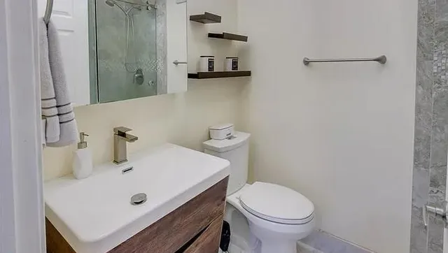 a bathroom with a sink a toilet and shower