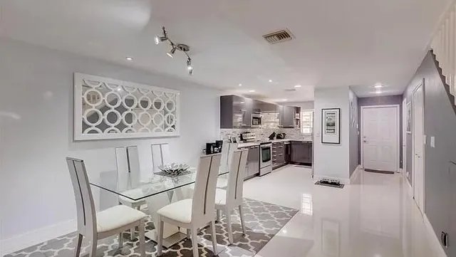 a living room with stainless steel appliances furniture and a view of kitchen