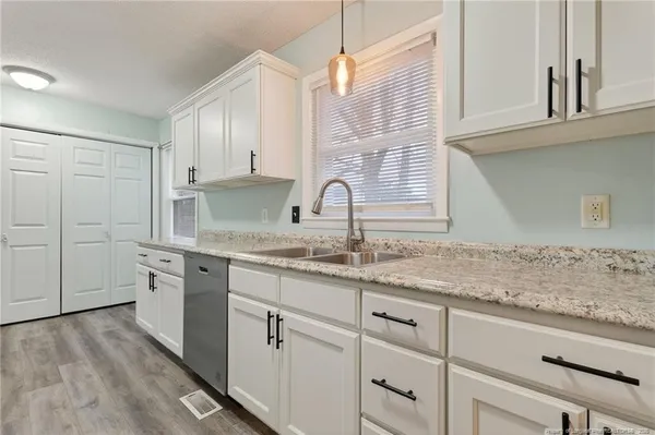 a kitchen with granite countertop white cabinets and white appliances