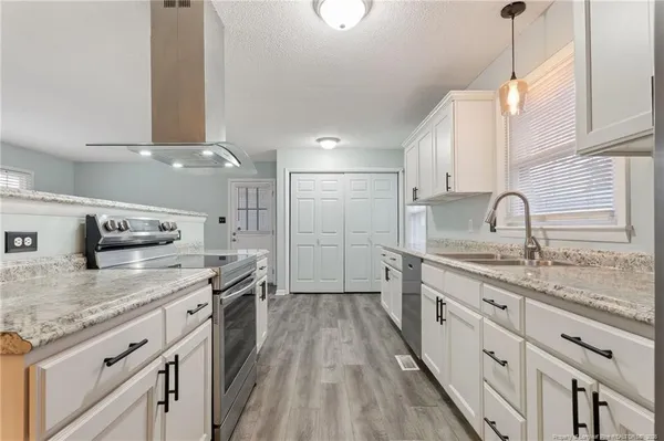 a kitchen with stainless steel appliances granite countertop a sink stove and cabinets