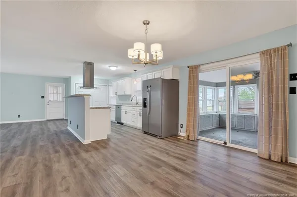 a view of a kitchen with wooden floor and a window