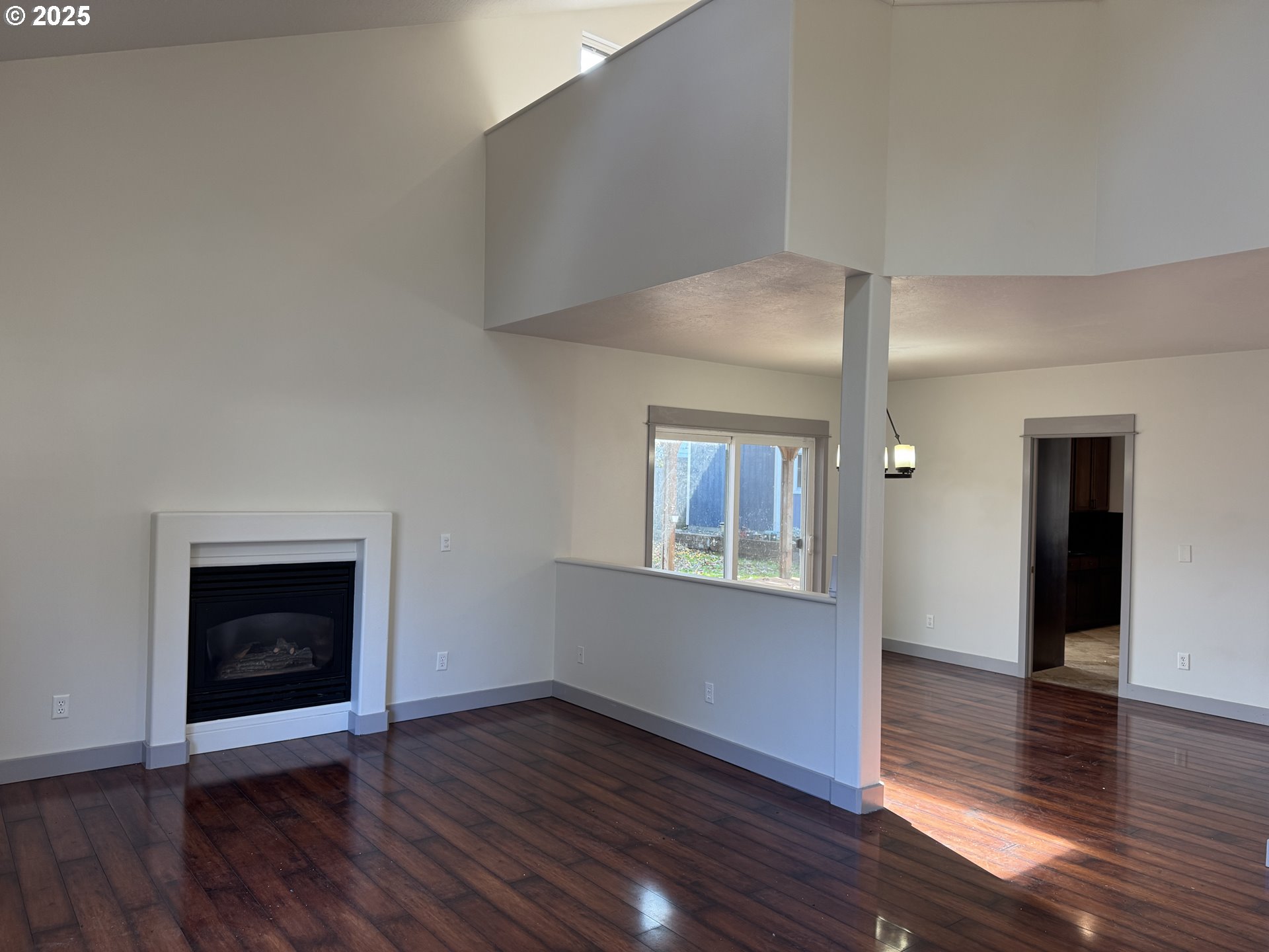 4015 Scenic Drive, Unit 4027 Eugene, OR 97404 - Photo 5 of 26 an empty room with wooden floor fireplace and windows