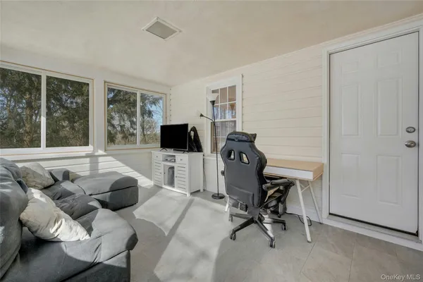 a view of a livingroom with workspace and a window