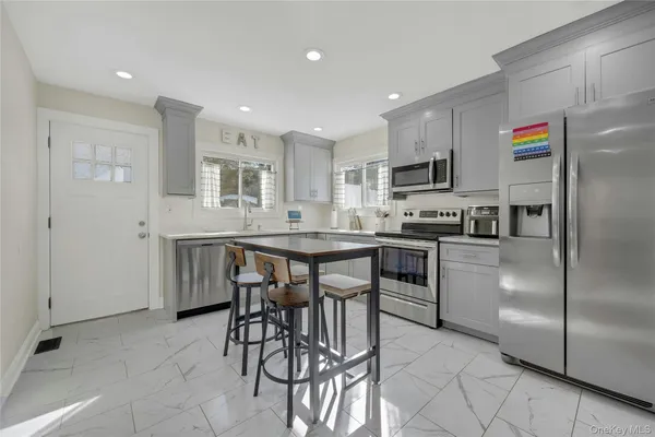 a kitchen with stainless steel appliances kitchen island granite countertop a refrigerator and a stove top oven
