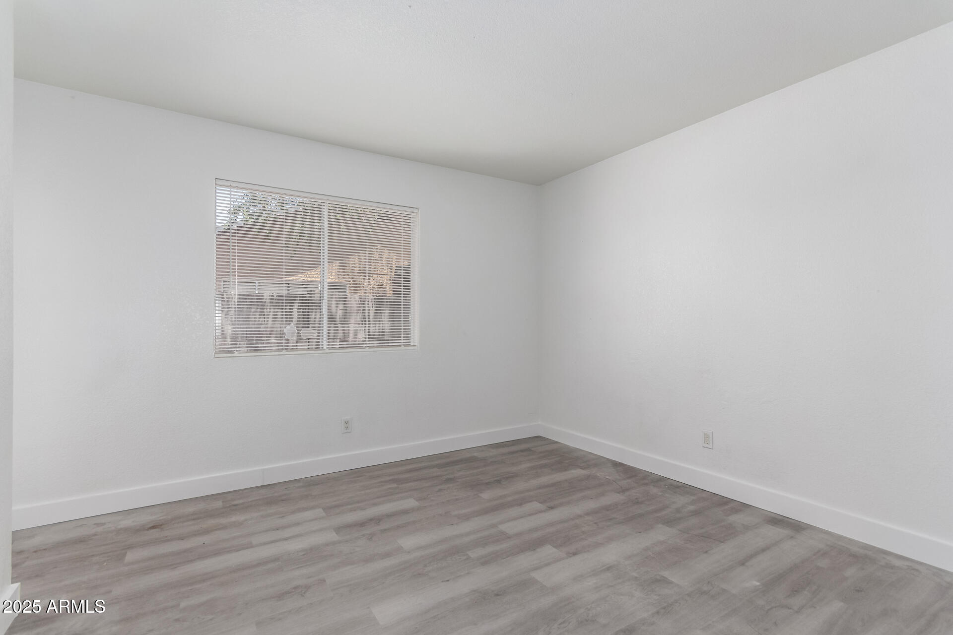 4162 East Wayland Road Phoenix, AZ 85040 - Photo 19 of 36 wooden floor in an empty room with a window