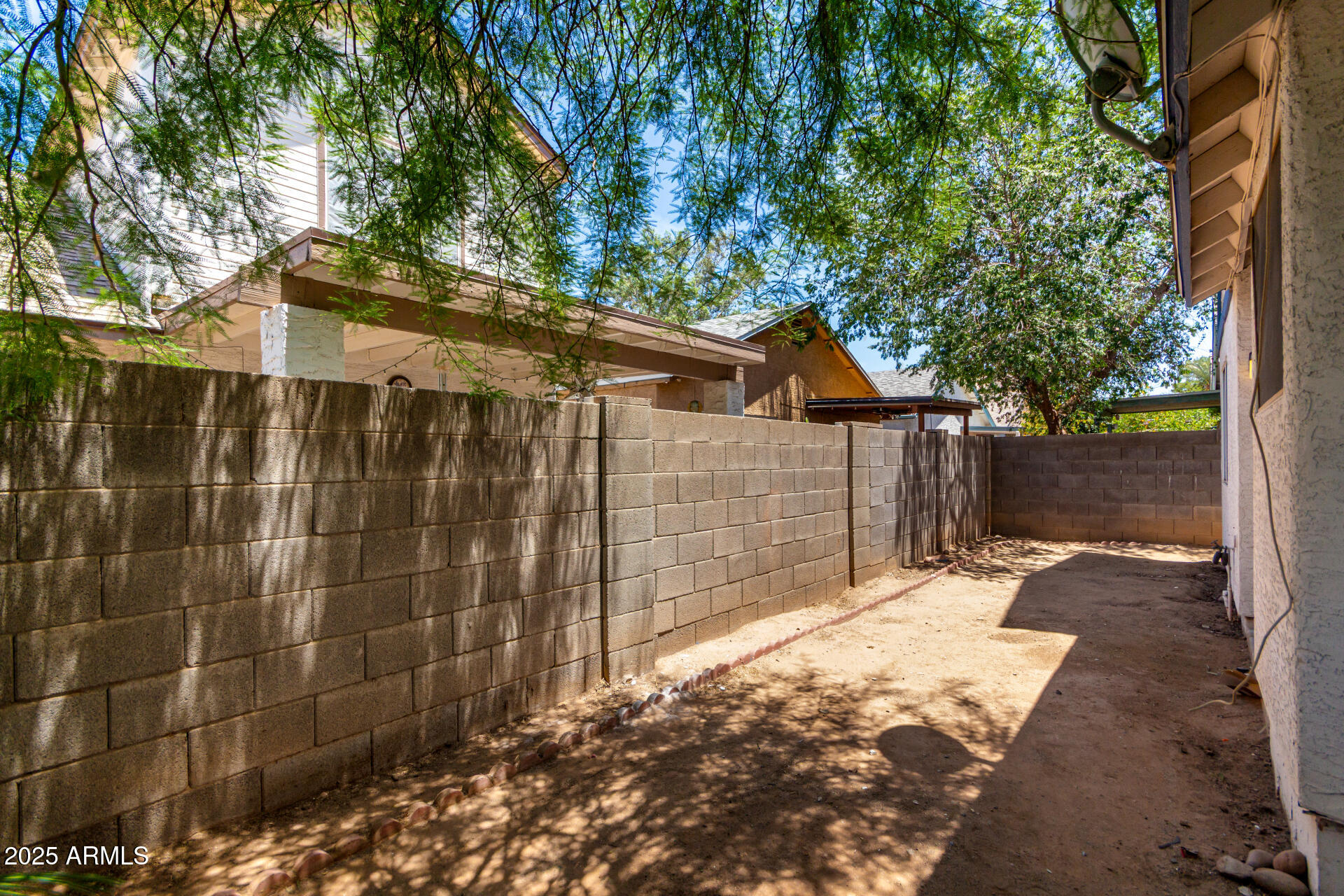 4162 East Wayland Road Phoenix, AZ 85040 - Photo 24 of 36 a backyard of a house with large trees and wooden fence