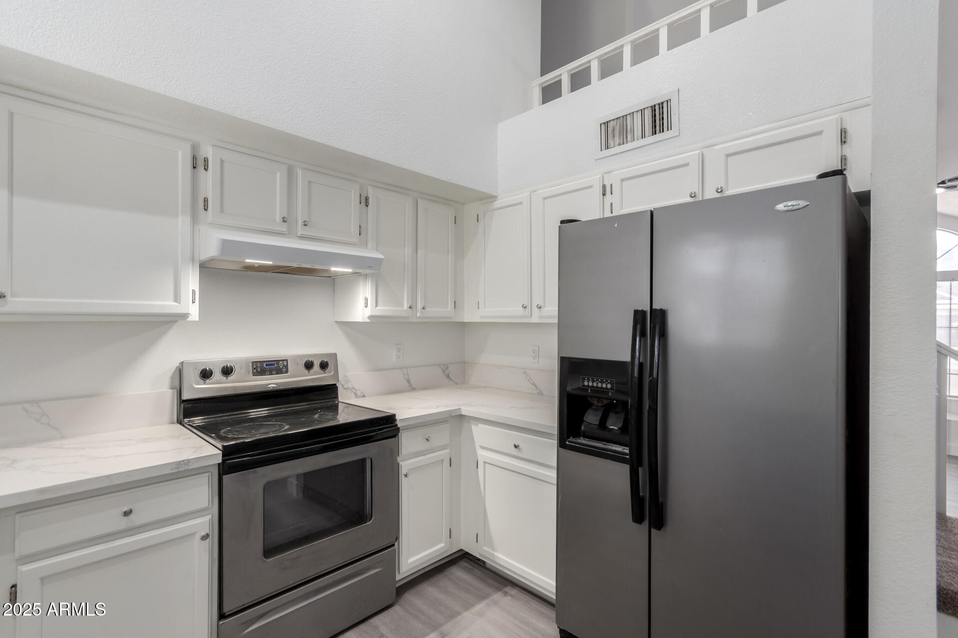 4162 East Wayland Road Phoenix, AZ 85040 - Photo 7 of 36 a kitchen with stainless steel appliances a refrigerator a stove and white cabinets