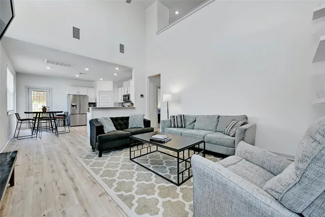 a living room with furniture wooden floor and a table