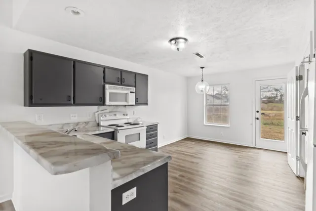 a kitchen with stainless steel appliances granite countertop a sink stove and microwave