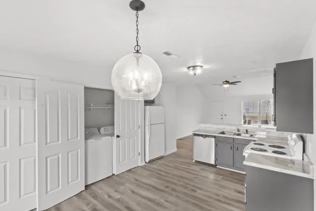 a kitchen with stainless steel appliances a sink a refrigerator and chandelier