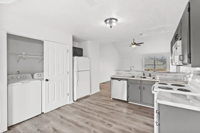a kitchen with a sink a stove cabinets and wooden floor