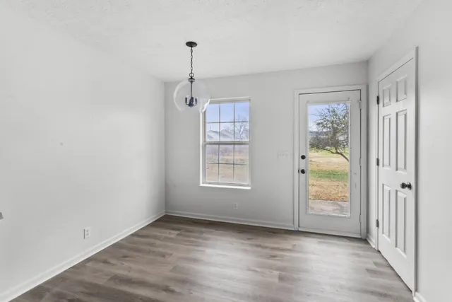 a view of an empty room with closet and windows
