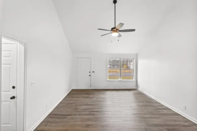 a view of room with window ceiling fan and hardwood floor