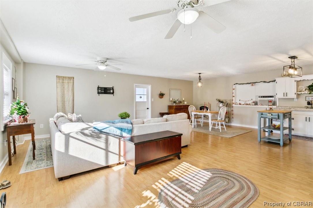 3255 Providence Road Hayes, VA 23072 - Photo 38 of 46 Living room with light wood-type flooring and ceiling fan with notable chandelier