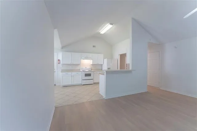 a kitchen with granite countertop white cabinets and white appliances