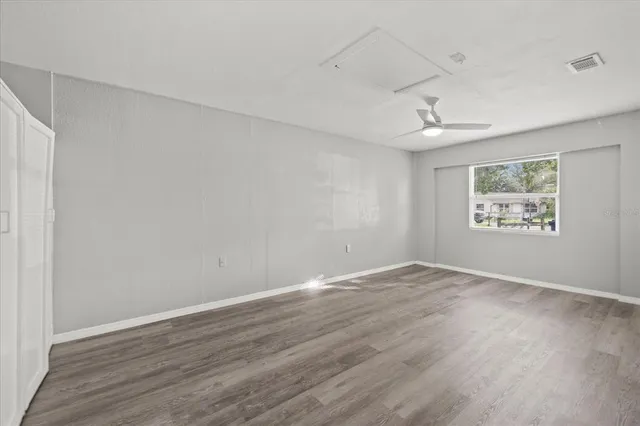 an empty room with wooden floor and window