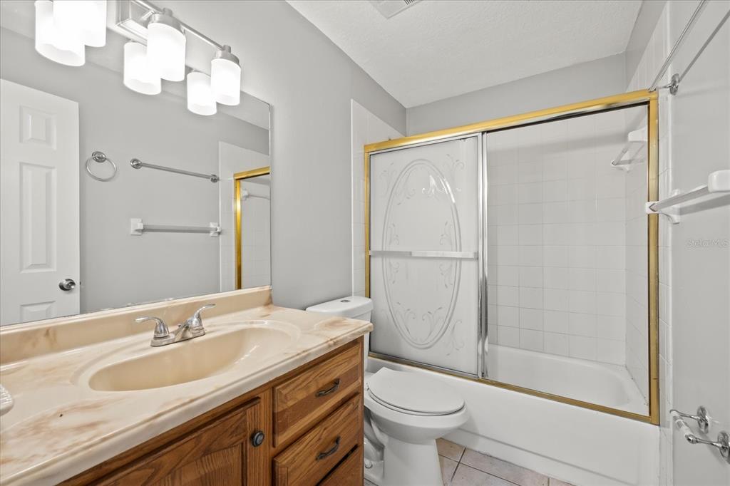 7445 Daggett Terrace New Port Richey, FL 34655 - Photo 20 of 35 a bathroom with a granite countertop sink toilet and shower