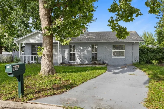 an aerial view of residential house with outdoor space and trees all around