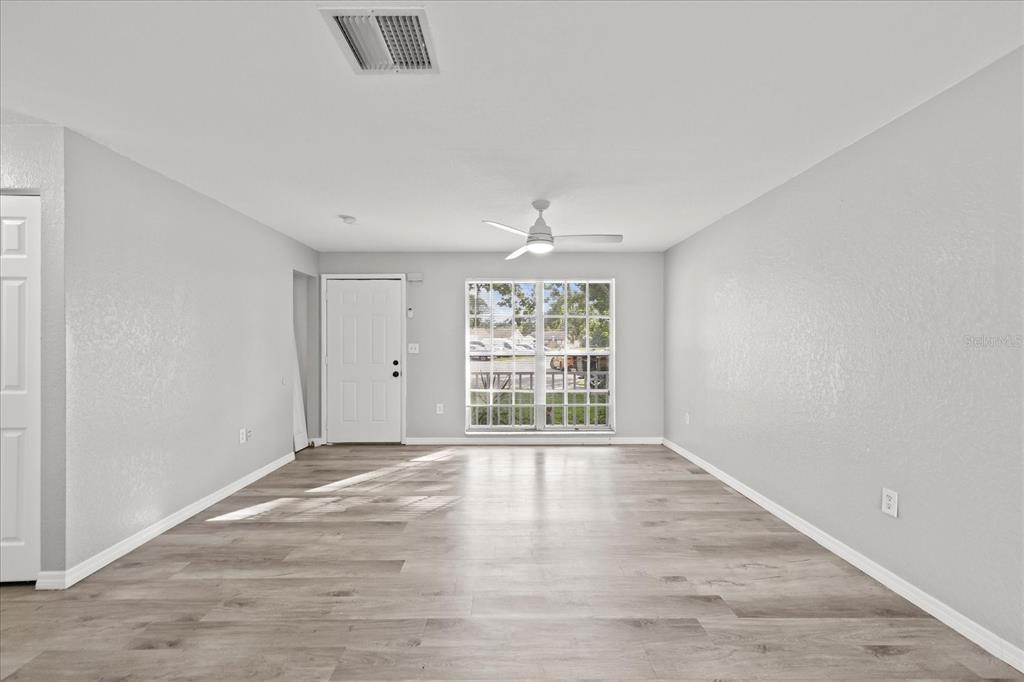 7445 Daggett Terrace New Port Richey, FL 34655 - Photo 4 of 35 a view of an empty room with wooden floor and a window