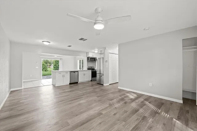 a view of a kitchen with wooden floor and a window