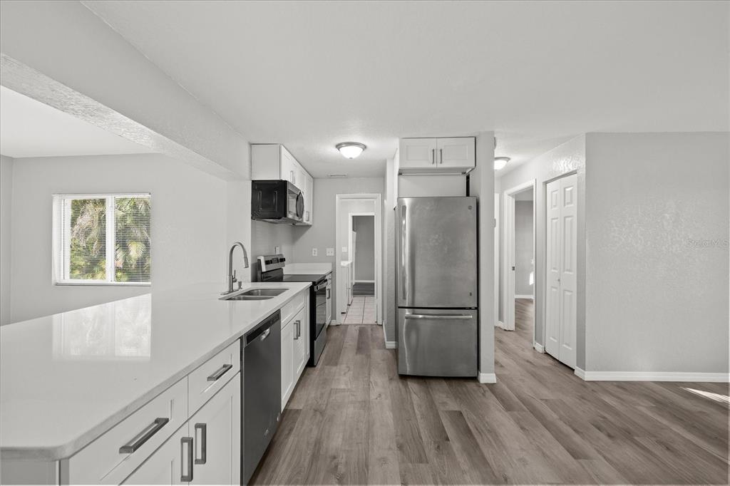 7445 Daggett Terrace New Port Richey, FL 34655 - Photo 6 of 35 a kitchen with a refrigerator a sink and a stove top oven