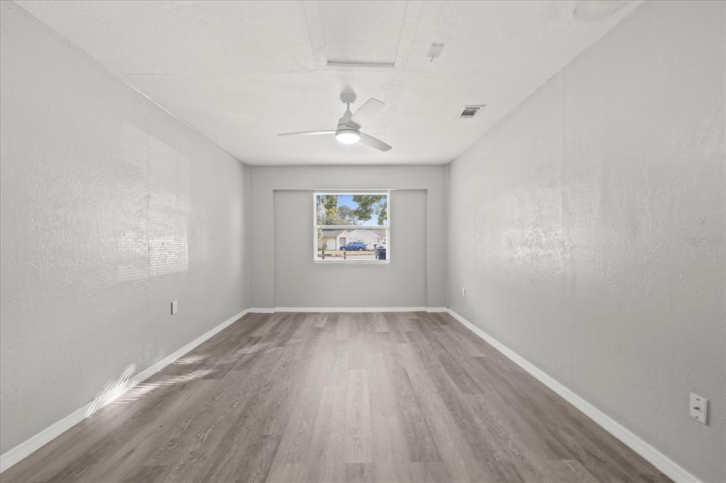 7445 Daggett Terrace New Port Richey, FL 34655 - Photo 8 of 35 an empty room with wooden floor chandelier and windows