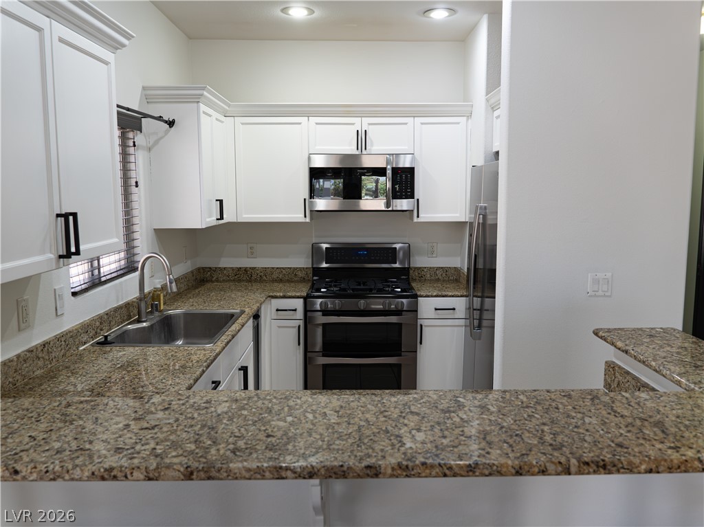 1466 Orange Jubilee Road Henderson, NV 89014 - Photo 4 of 15 A well-appointed kitchen offers ample counter space and modern stainless steel appliances for culinary endeavors.