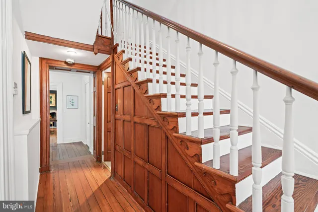 a view of staircase with wooden floor and white walls