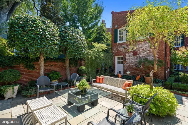 a view of patio with a table and chairs and potted plants