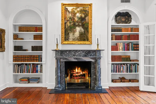a living room with a fireplace and a book shelf