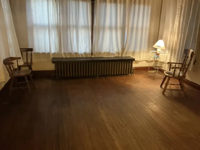 a view of a room with wooden floor and a window