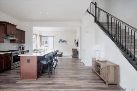 a kitchen with stainless steel appliances granite countertop a kitchen island hardwood floor sink and stove